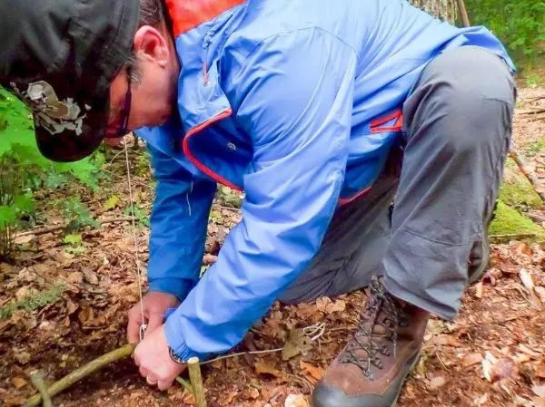 Zwei Äste werden mit Schnur zu einer Konstruktion verbunden