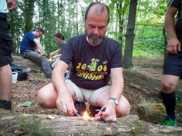 Feuerstahl erzeugt Funken auf Zunder in einem Waldgebiet