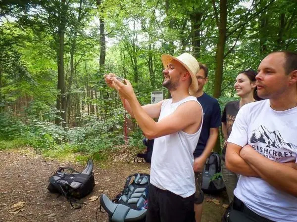 Gruppe beobachtet einen Mann, der ein Tier in den Händen hält