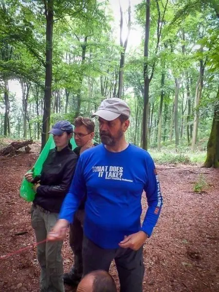 Gruppendiskussion im Wald mit mehreren Personen und Ausrüstung