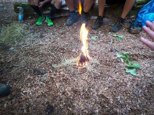 Kleine Flamme aus Zunder auf dem Boden