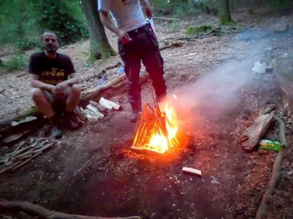 Kleine Flamme brennt im Lagerfeuer, Rauch steigt auf