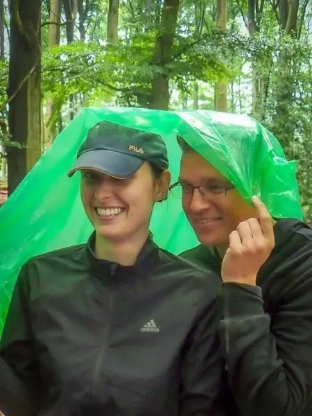 Zwei Personen stehen unter einer grünen Tarp-Notunterkunft im Wald