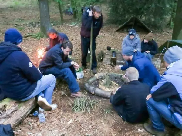 Gruppe bereitet Zunder für ein kleines Bodenfeuer im Wald