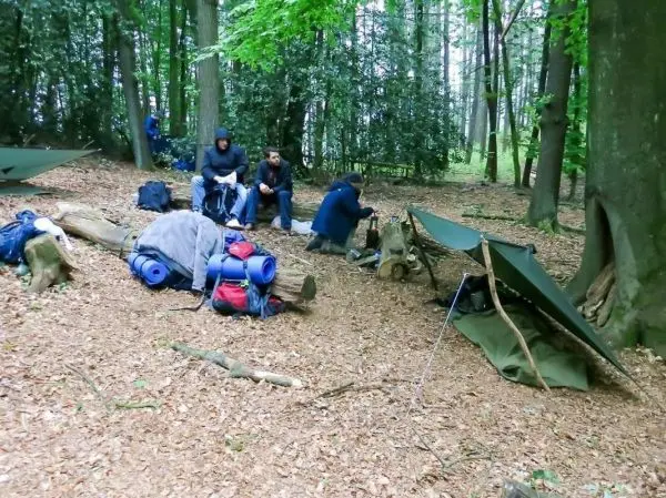 Lagerplatz mit Tarp-Notunterkünften und Rucksäcken im Wald