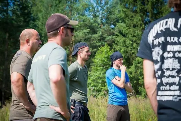 Gruppe von Personen hört aufmerksam einer Erklärung im Freien zu