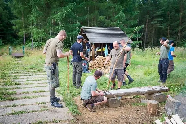Gruppierung arbeitet an Holzstücken und Seilbindungen in einer Waldumgebung