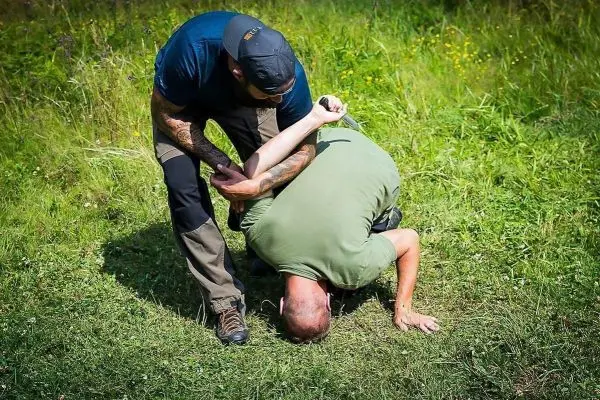 Kampftechniken werden demonstriert, während eine Person kontrolliert wird