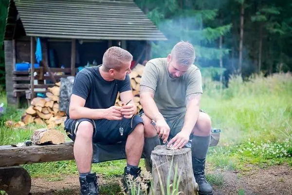 Zunder wird auf einem Holzstück bearbeitet, Rauch steigt auf