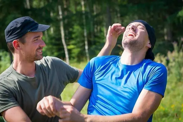 Zwei Männer lachen und interagieren spielerisch im Freien