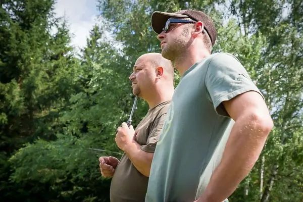 Zwei Männer stehen im Freien und beobachten die Umgebung