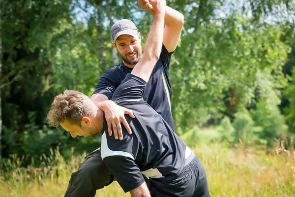 Zwei Personen üben eine Selbstverteidigungstechnik im Freien