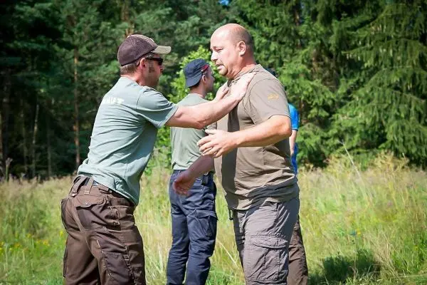 Zwei Personen üben eine Selbstverteidigungstechnik im Freien