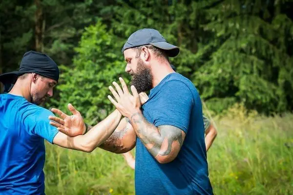 Zwei Personen üben eine Selbstverteidigungstechnik im Freien