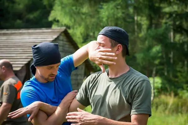 Zwei Personen üben eine Selbstverteidigungstechnik im Freien