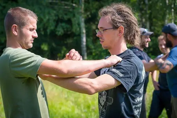 Zwei Personen üben eine Technik zur Armkontrolle im Freien