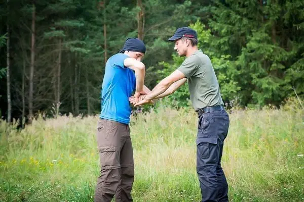 Zwei Personen üben eine Technik zur Handbefreiung im Freien