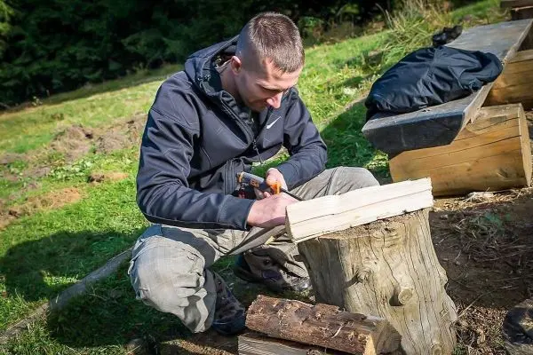 Messer bearbeitet Holzstück auf einem Baumstumpf