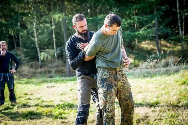 Person demonstriert eine Technik zur Kontrolle einer anderen Person beim Training