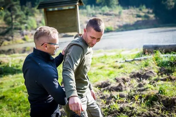 Person hilft anderer Person beim Gehen im Freien