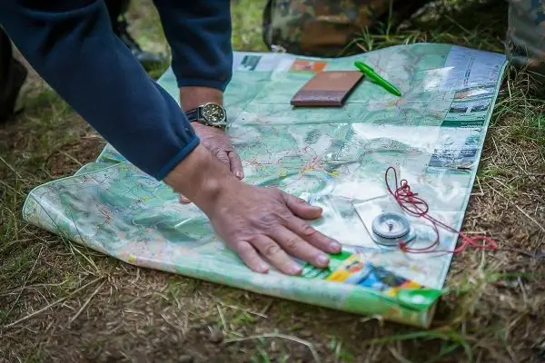 Person legt Hand auf eine ausgebreitete Karte