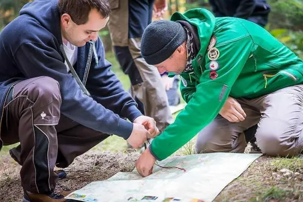 Zwei Personen betrachten gemeinsam eine Karte auf dem Boden