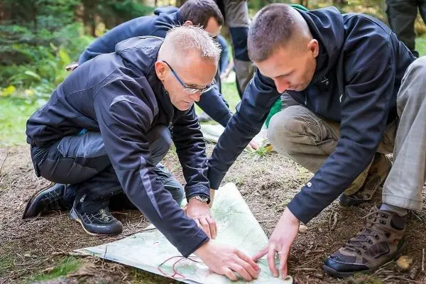 Zwei Personen legen eine Karte auf den Boden und markieren Punkte