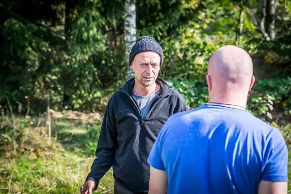 Zwei Personen stehen sich in einer natürlichen Umgebung gegenüber