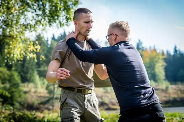 Zwei Personen üben eine Selbstverteidigungstechnik im Freien