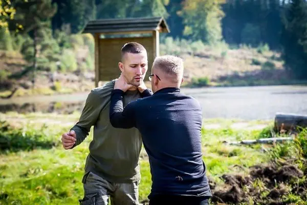 Zwei Personen üben eine Selbstverteidigungstechnik im Freien