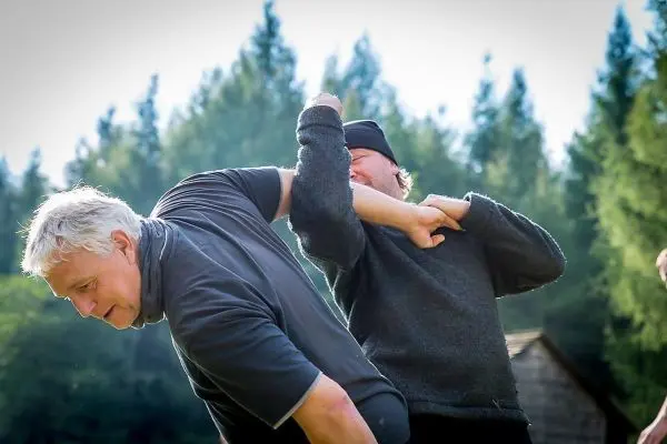 Zwei Personen üben eine Selbstverteidigungstechnik im Freien