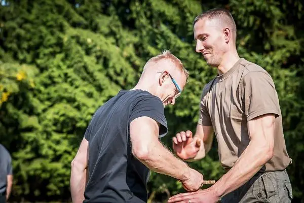 Zwei Personen üben eine Selbstverteidigungstechnik im Freien