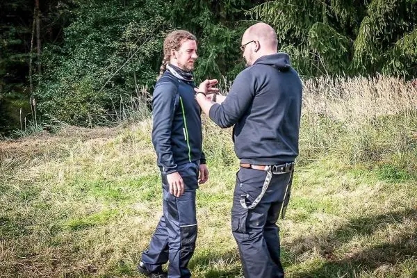 Zwei Personen üben eine Technik zur Handbefreiung im Freien