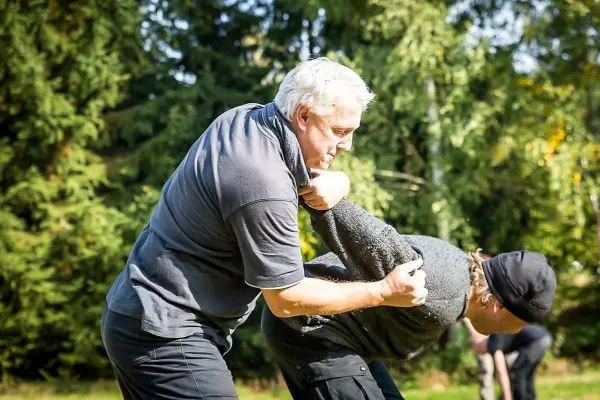 Zwei Personen üben eine Technik zur Kontrolle des Gegners im Freien