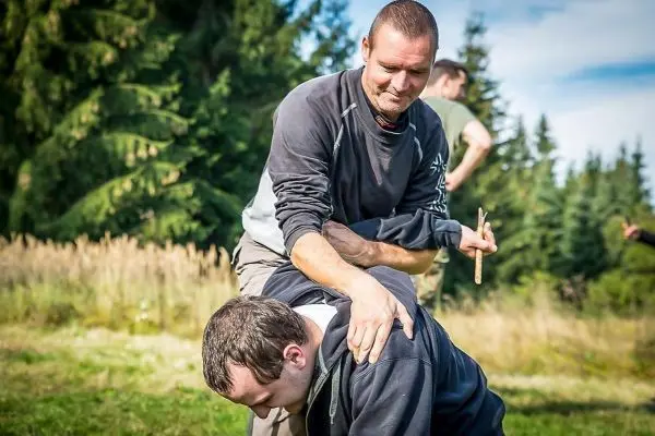 Zwei Personen üben eine Technik zur Kontrolle in einer Trainingssituation im Freien