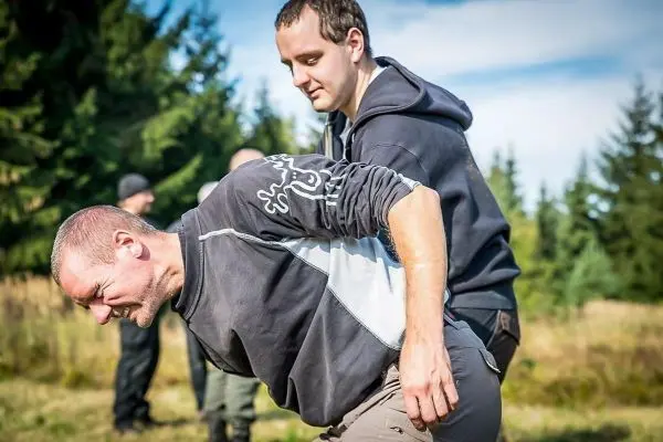 Zwei Personen üben eine Technik zur Unterstützung in einer Outdoor-Umgebung