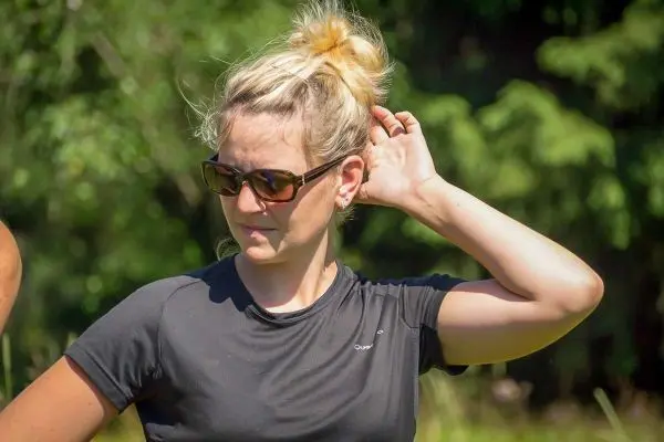 Eine Person mit Sonnenbrille streicht sich das Haar zurück