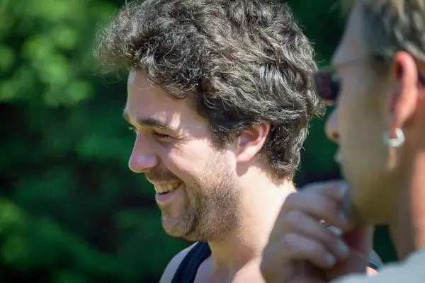 Es sind zwei Männer im Gespräch, einer lächelt und schaut zur Seite