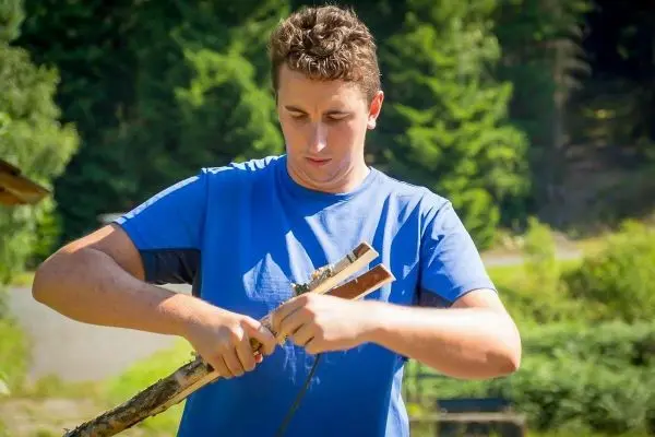 Holzstück wird mit einem Messer bearbeitet