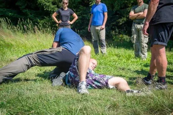 Kampfsportübung mit zwei Personen auf dem Boden in einer Wiese