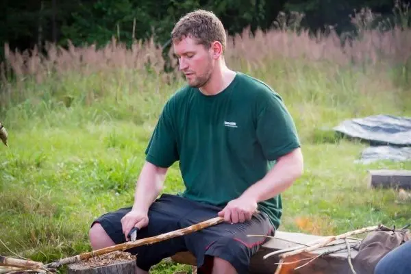 Messer bearbeitet Holzstück auf einer Holzunterlage