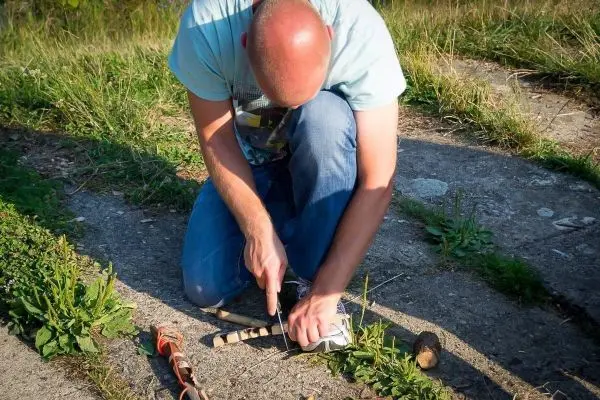 Messer schneidet in ein Stück Holz auf dem Boden