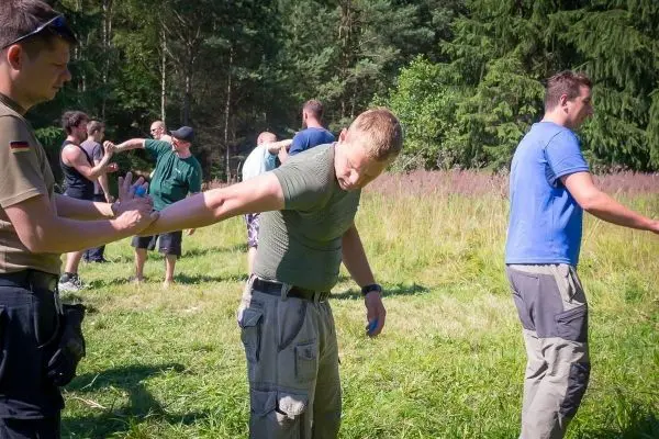 Person zeigt einer anderen Person eine Technik im Freien