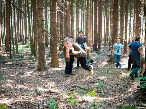 Selbstgebaute Seilquerung wird von einer Person überquert, andere beobachten im Hintergrund