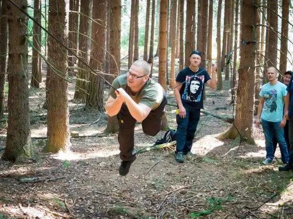 Selbstgebaute Seilquerung wird von einer Person überquert, während andere zuschauen