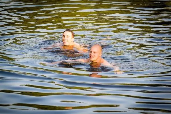 Zwei Personen schwimmen im Wasser und lächeln