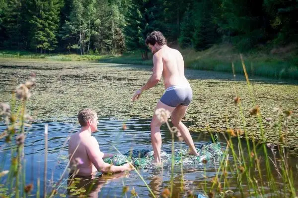 Zwei Personen stehen auf einer improvisierten Plattform im Wasser