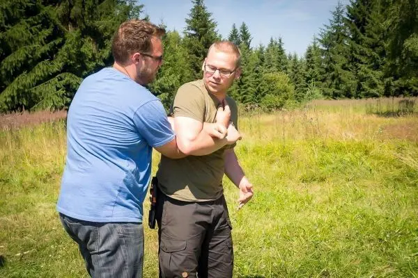 Zwei Personen üben eine Selbstverteidigungstechnik im Freien