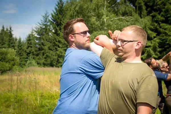 Zwei Personen üben eine Selbstverteidigungstechnik im Freien