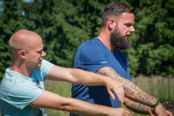 Zwei Personen üben eine Technik zur Armkontrolle im Freien